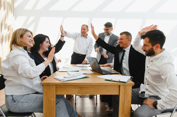 Business team celebrating success during meeting with high five