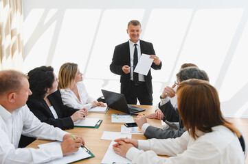 Senior manager leading a business meeting with his team