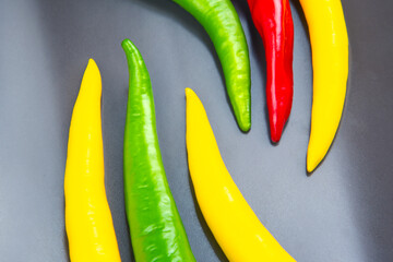 Colorful chili peppers arranged artistically on a black surface creating a vibrant display