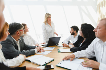 Business team meeting with female leader discussing strategy in modern office