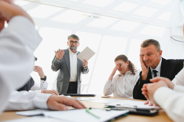 Senior businessman leading a meeting with disappointed colleagues