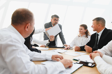 Business team discussing documents during important meeting in office