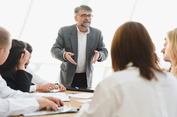 Senior businessman leading a meeting with his team