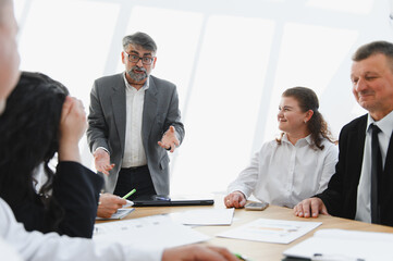 Senior manager leading a business meeting with his team