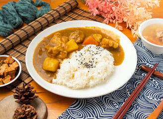 Japanese Curry Chicken Rice Set with Savory Sauce and Side Dishes in plate side view of Asian food