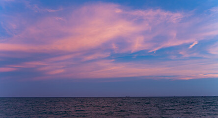 Colorful sunset and dusk skies with soft cloud formations over the sea horizon. Peaceful twilight landscapes ideal for background, nature themes, or tranquil mood concepts.