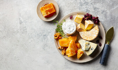 Cheese assortment on a platter. Dark background. Close up. Copy space. Top view.