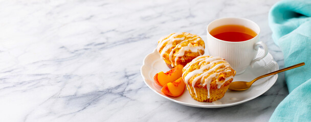 Peach cupcakes, muffins with cup of tea. Marble table. Blue background. Close up.