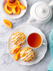 Peach cupcakes, muffins with cup of tea. Marble table. Close up. Top view.