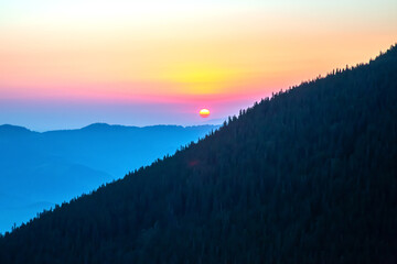 Sunset over the mountains with vibrant colors in the sky at dusk