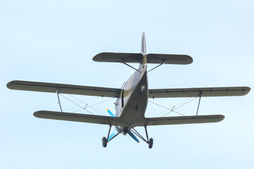 Aircraft flying over a field during daylight hours for agricultural purposes © photosaint