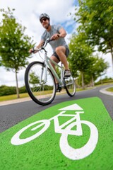 Naklejka premium Cyclist riding on a bike path in a park