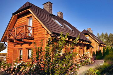 Nowoczesne drewniane domy całoroczne z bali, pod klucz.Widok na drzwi frontowe , okna i balkon (wszystko z drewna). © Pol Badger