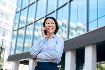 Asian mature business woman manager using cell phone for connection call communication standing...
