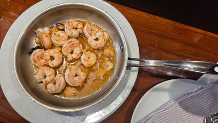 Delicious shrimp dish in pan - gourmet seafood cooking concept. Spanish tapas. Bar in Madrid. Traditional Spanish dish