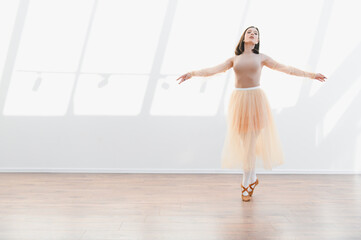 Ballerina dancing elegantly in light filled studio, graceful movement and artistic expression