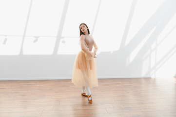 Ballerina performing graceful dance in sunlit studio