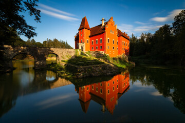 Obraz premium Fairytale Red Chateau Červená Lhota reflected in lake at sunset, South Bohemia, Czech Republic – romantic historic landmark surrounded by nature