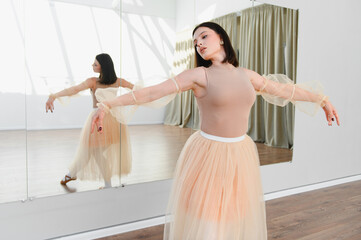 Ballerina practicing in front of mirror in dance studio