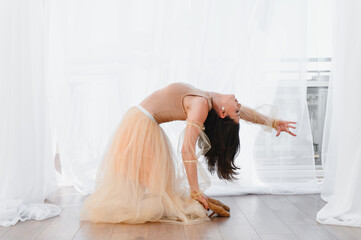 Ballerina performing a backbend in dance studio with tulle skirt