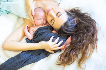 Mother gently cradles her newborn baby in a cozy and serene setting at home