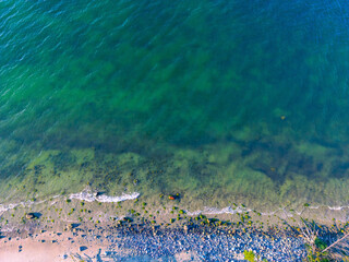 Aerial photo of a pebble beach with green waters and small waves, view along the coast of the Baltic Sea near the North Perd in 18586 Göhren, island of Rügen, Germany
