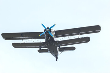 Classic biplane flying against a clear sky during daylight hours