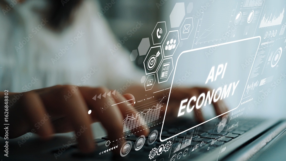 Poster focused hands typing on laptop with overlaid graphics representing api economy and digital innovatio