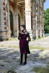 Fototapeta premium Halloween: Girl with black braids in gothic dress abandoned mansion background. 