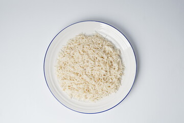 Cooked white rice in a plate, plan white rice in a white plate isolated on the white background shot in a soft studio lights
