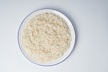 Cooked white rice in a plate, plan white rice in a white plate isolated on the white background shot in a soft studio lights