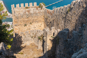 The remnants of an ancient castle stand rugged against a clear blue sky, with a breathtaking view...