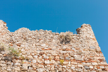 The weathered stone wall stands against a vibrant blue sky, showcasing its historical significance...