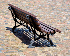 Wooden Bench on Cobblestone Pavement