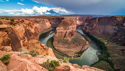 Panoramic view of Horseshoe Bend, a dramatic meander of the Colorado River through a canyon in Arizona, under a partly cloudy sky.