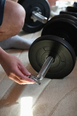Collapsible dumbbell and hand that removes or sets the spring lock to secure the discs