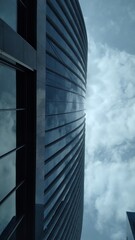 View from below of a glass building and a sunny sky in the background