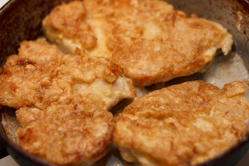 Golden delicious fried chicken cutlets in a skillet. Crispy texture and appetizing appearance