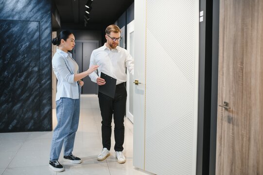 Salesman showing door to customer in hardware store