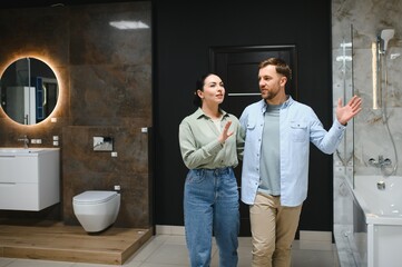 Couple choosing bathroom fixtures in a modern showroom