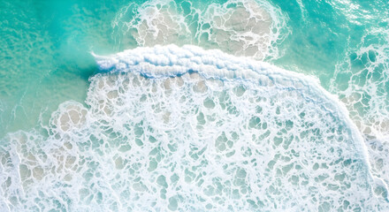 Naklejka premium Aerial view of waves breaking on a beach