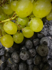 Close-up of white Kishmish grapes and fresh blueberries showcasing natural freshness, vibrant colors, and detailed textures. Perfect for fruit, food, and healthy lifestyle theme