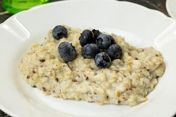 A bowl of oatmeal topped with fresh blueberries. 