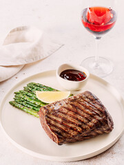 Grilled meat steak on plate with lemon and asparagus