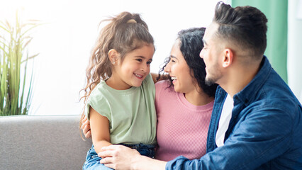 Happy Middle Eastern Parents Playing With Their Little Daughter At Home, Cheerful Arab Mom And Dad Laughing And Having Fun With Adorable Child, Enjoying Time Together, Copy Space