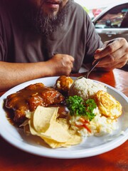Bearded Man Enjoying Chicken Chops with Rice and Egg Meal