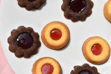 chocolate cupcakes and cupcakes with jam on white plate top view 