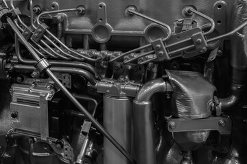 Shown is a large engine with many tubes, bolts and various parts. Auto service concept background.