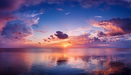 Naklejka premium a vibrant sunset fills the sky with shades of pink orange and blue reflecting on the serene waters of the sea gentle clouds float above creating a peaceful atmosphere