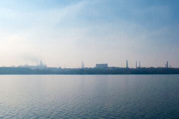 Obraz premium Industrial landscape of Zaporizhzhia. Factory pipes over the Dnipro river.